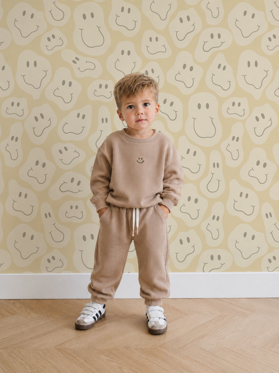 Le papier peint « Happy Shapes » en jaune sur le mur d'une chambre d'enfant